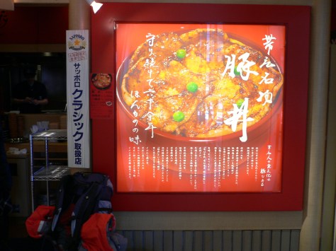 出了JR票閘口後，向ESTA西館方向一直走，遠遠看到紅色小店，認清這個招牌相片海報門屏，別走錯！